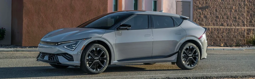 Kia EV6 electric crossover parked on a city street with a sleek, modern design.