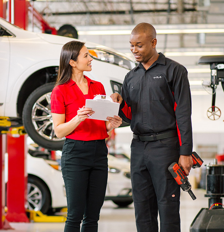 Technician rotating a tire on a Kia in the service lane at Planet Kia Charlotte